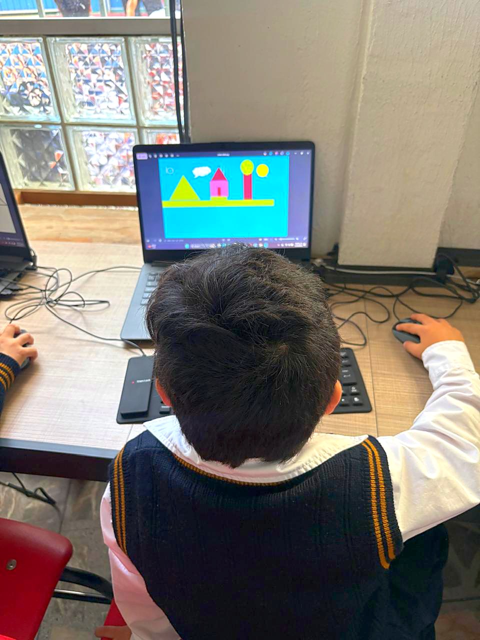 Alumno de preescolar dibujando en computadora